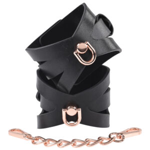 Sex and Michief S&M Brat Handcuffs from Sportsheets. Show your them you always get what you want with restraints that will leave you begging for more. The Brat Handcuffs feature corset like cut outs and a short Rose Gold chain for a sassy look. Who knows