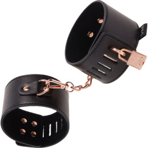 Sex and Mischief Brat Locking Cuffs by Sportsheets - Rose Gold and Black. Give your brattiest partner a reason to reconsider their actions with the Sex & Mischief Brat Locking Cuffs Set! Crafted with sleek black vegan leather and adorned with captivating