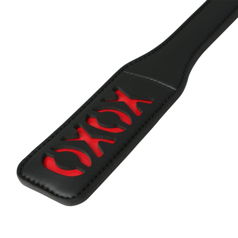 Sex and Mischief Collection XOXO Paddle Black. This black vinyl paddle features a red cheeky XOXO design that leaves a sexy impression on your partner! Details black vinyl paddle with XOXO design. Leaves a great impression! Black on red. Materials: Nickel