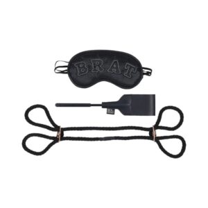 Sex and Mischief Knotty Brat Kit from Sportsheets. Teach your bratty bottom how to properly submit with the perfectly curated Knotty Brat Kit! Keep them restrained with the included rope handcuffs in a stunning black with rose gold metal accents while you